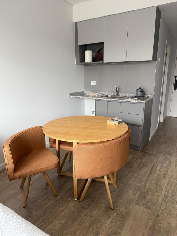 a kitchen with a wooden table and two chairs at Mono 611 in Neuquén