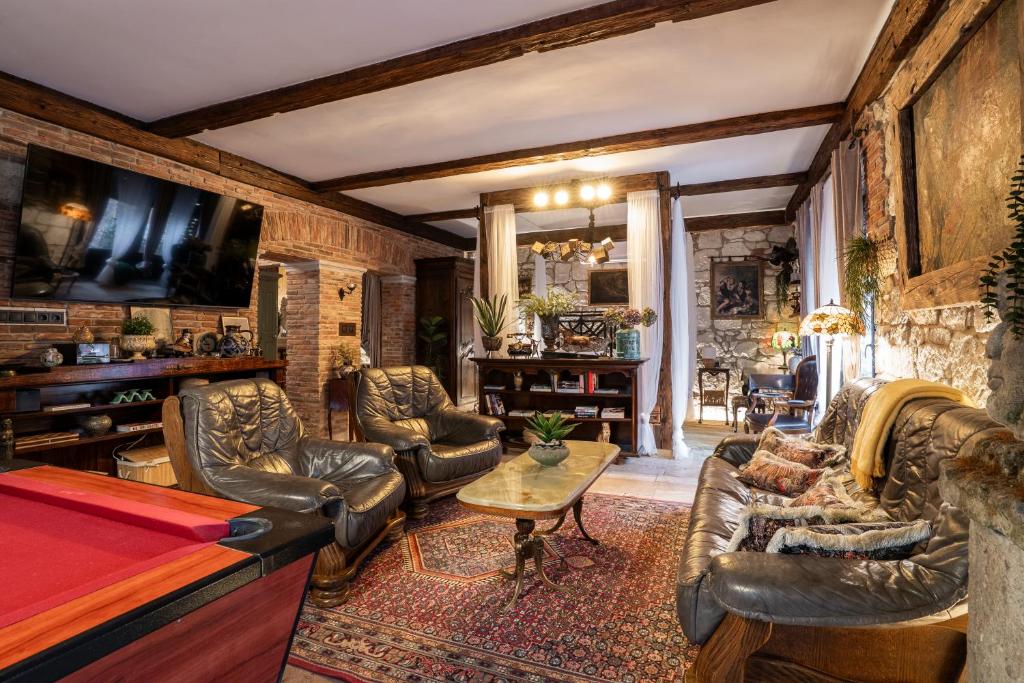 a living room with leather furniture and a pool table at Veritas in Tokaj