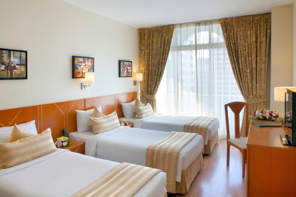 a hotel room with two beds and a window at Landmark Hotel in Dubai