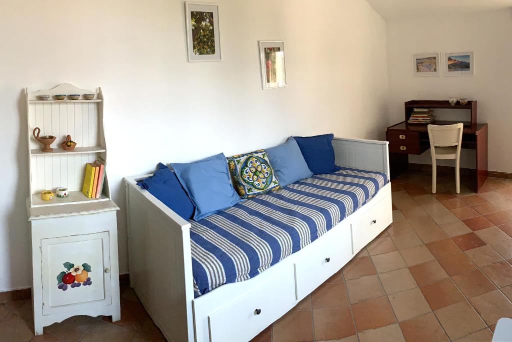 a bed with blue pillows on it in a room at Casa del Cedro in Brucoli