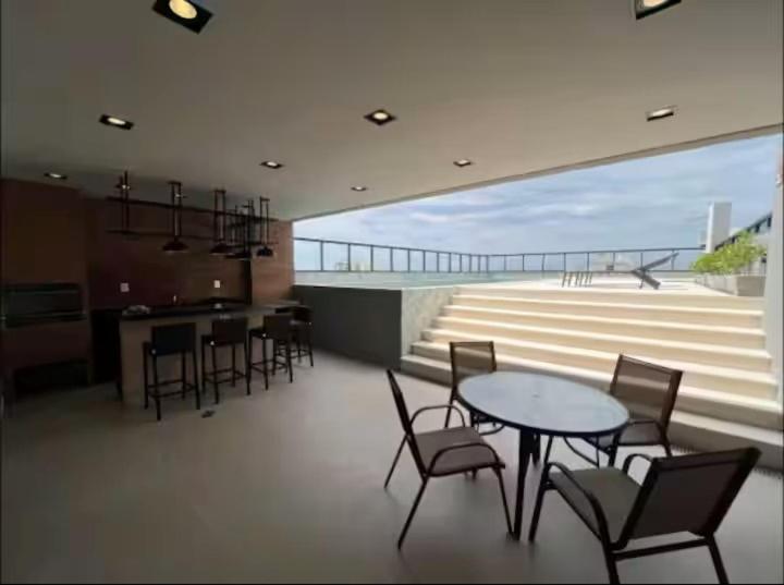 a dining room with a table and chairs and a balcony at Flat Exclusivo Studio Cuiabá 1604 in Cuiabá