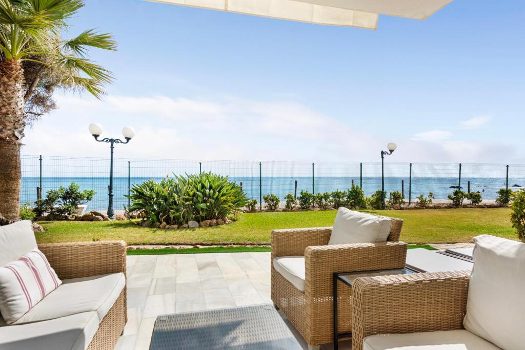 a patio with chairs and a view of the ocean at The loving hummingbird in Mijas Costa