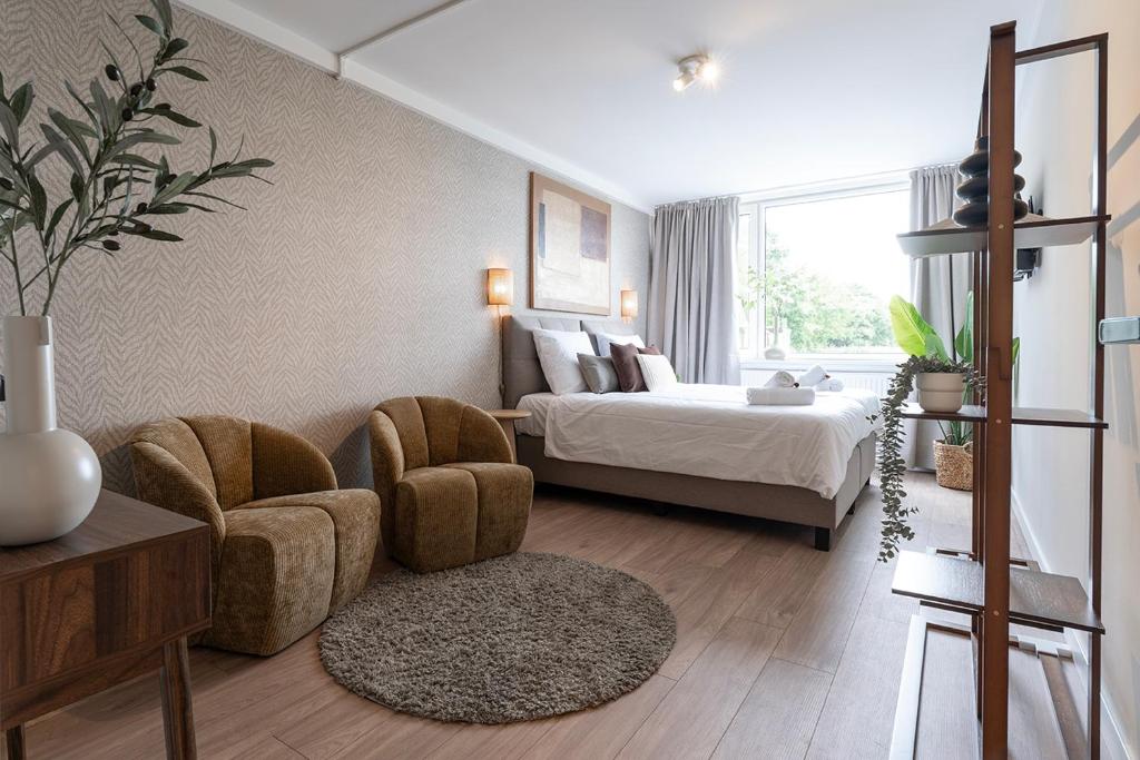 ein Schlafzimmer mit einem Bett, einer Couch und einem Sessel in der Unterkunft University Tilburg Affordable Room Walk In Nature in Tilburg