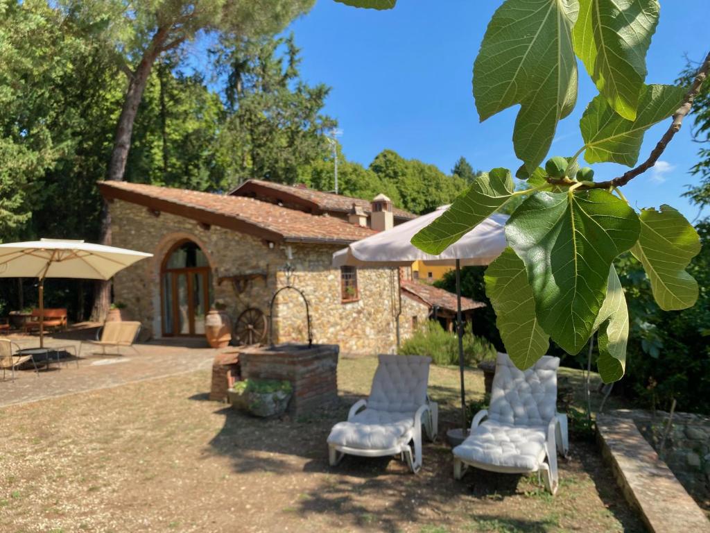 a yard with chairs and a house with a tree at Berenice in Chianti - Authentic Tuscan Country House in Bagno a Ripoli