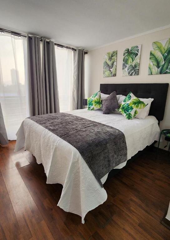 a bedroom with a large bed with white sheets and pillows at Familiar en el centro de Santiago 16 B in Santiago