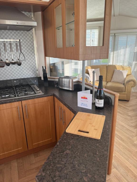 a kitchen with a counter with a bottle of wine on it at marine getaways caravan hire winchester in Rhyl