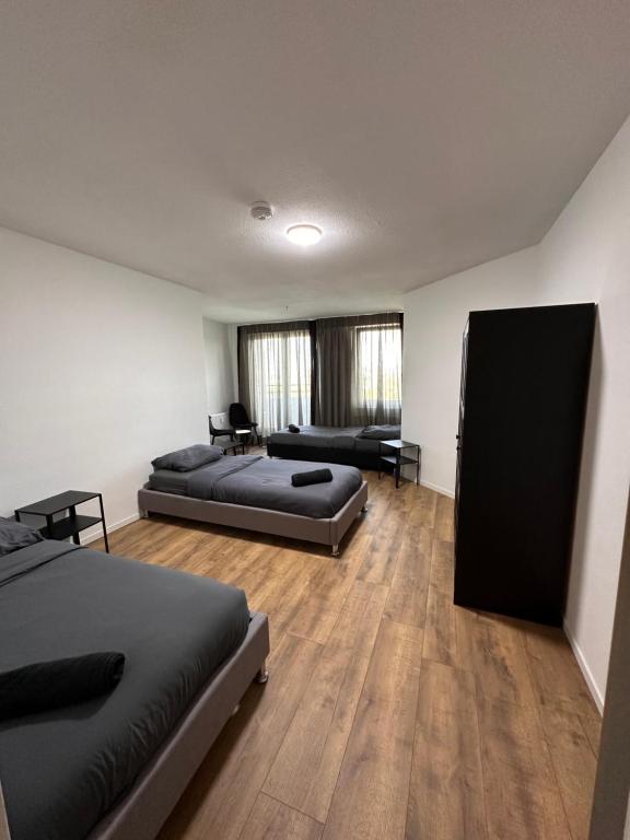 a large room with two beds and a couch at Airport Apartments Rüsselsheim in Rüsselsheim