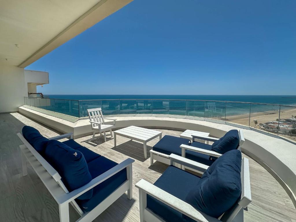 a balcony with chairs and a view of the beach at Waves & Views Luxury 3BR Oceanfront Condo in Puerto Peñasco