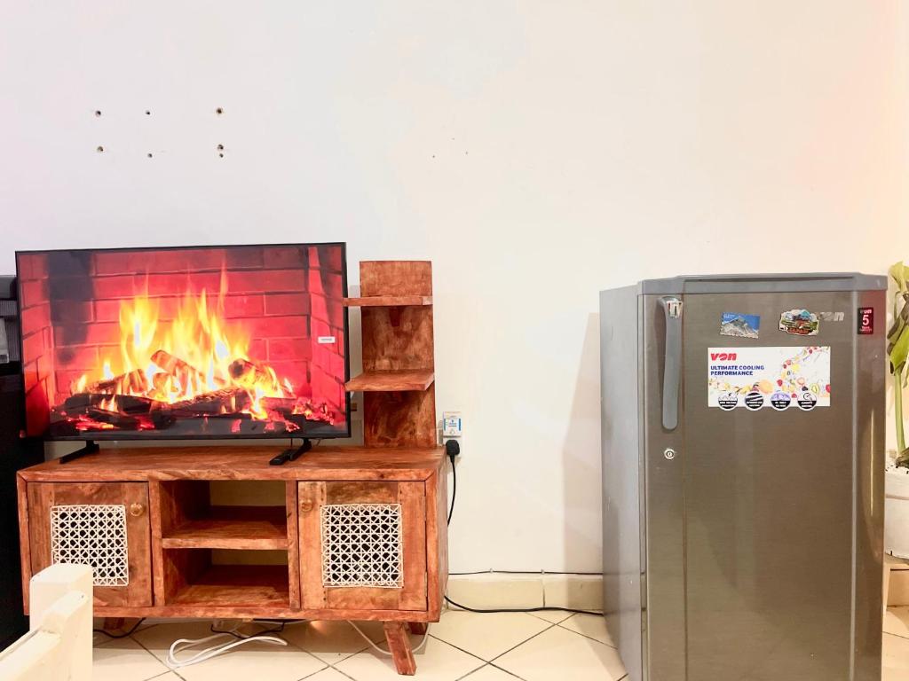 a fireplace in a living room next to a refrigerator at Nyumbani Studio in Ukunda Airport