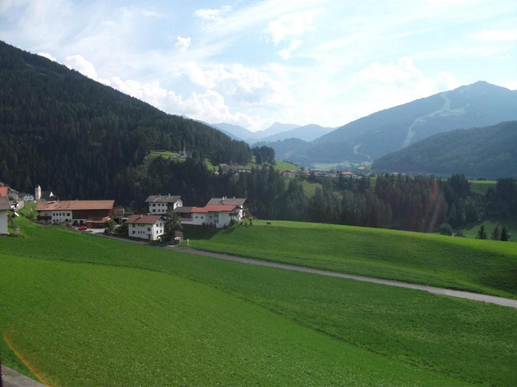 a green field with houses and mountains in the background at Ferienwohnung 2 Ferienhaus Gassner In Navis in Navis