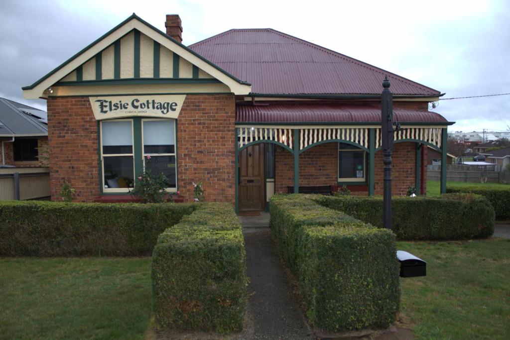 ein Backsteingebäude mit Hecken davor in der Unterkunft Elsie Cottage in Devonport