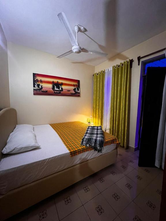 a bedroom with a bed and a ceiling fan at F&M comfy homes in Mombasa