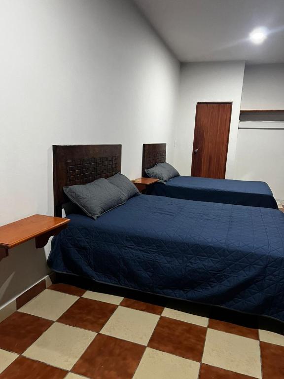 a bedroom with two beds with blue sheets and a desk at Casa Camino Real, Habitación 1, Baño privado, Cafetera Escritorio in Ciudad Valles