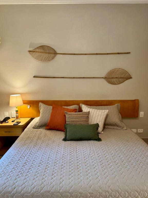 a bedroom with a large white bed with pillows at Ilhabela Flat in Ilhabela