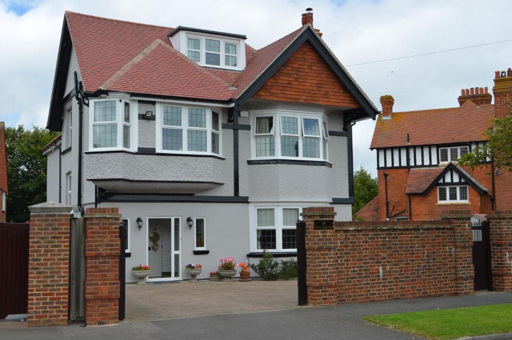 a white and black house with a brick fence at Foy House in Folkestone