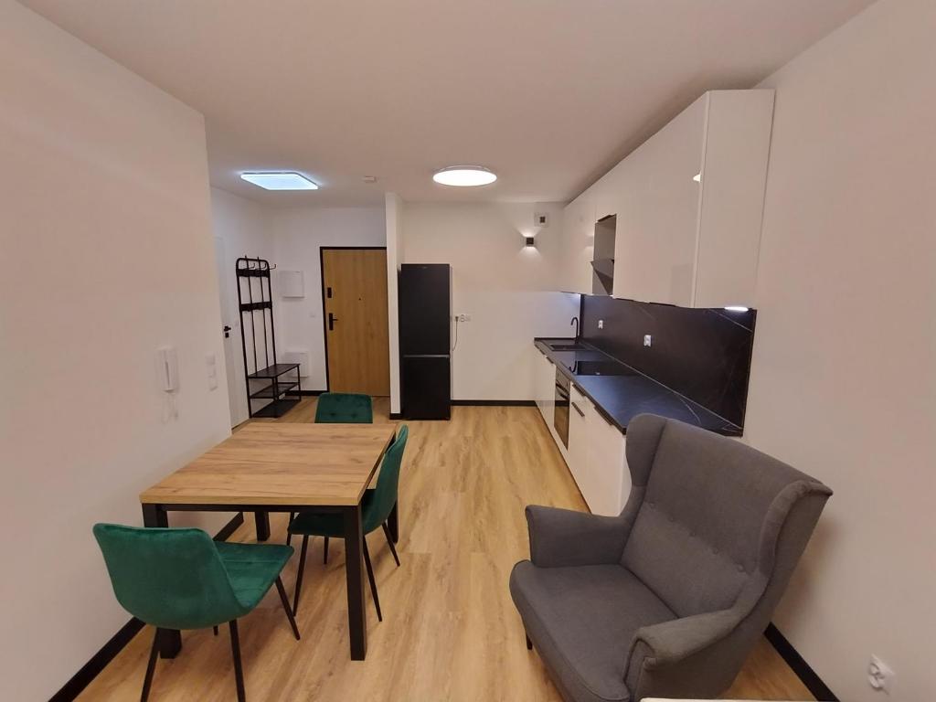 a living room with a table and chairs and a kitchen at Podłęże Trawniki Industrial Zone 