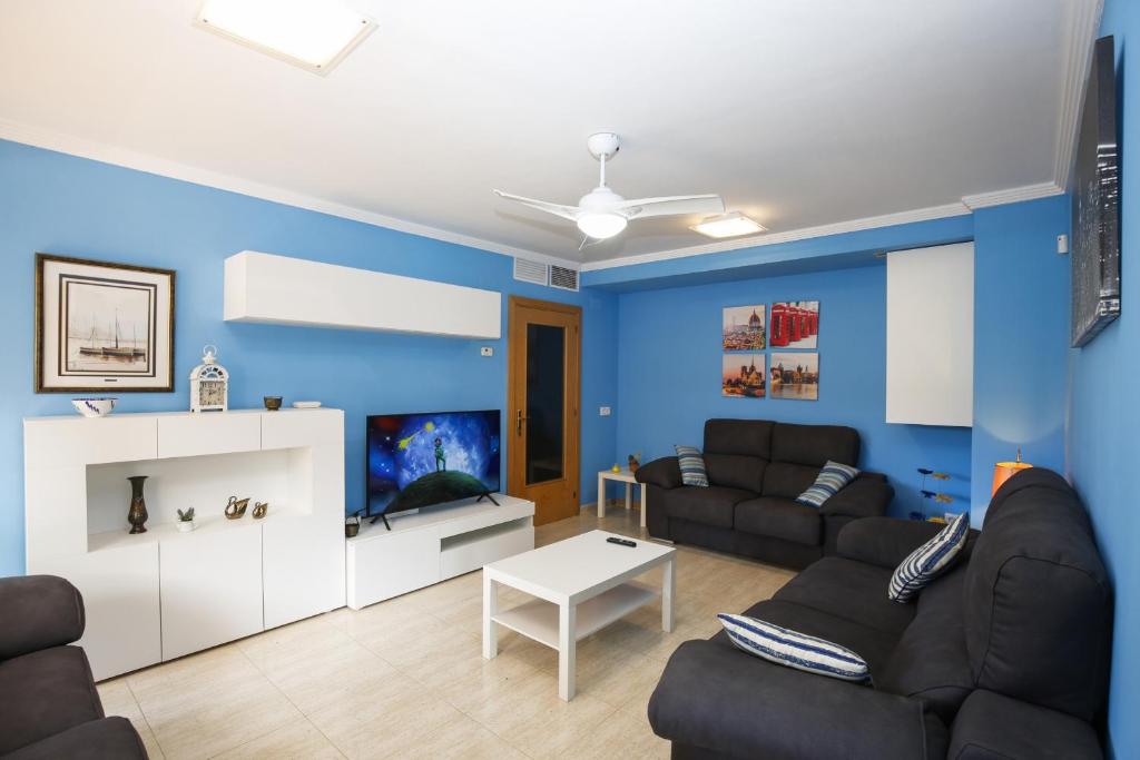 Una sala de estar con paredes azules y un sofá negro. en Egeo Only Families Planetcostadorada, en La Pineda