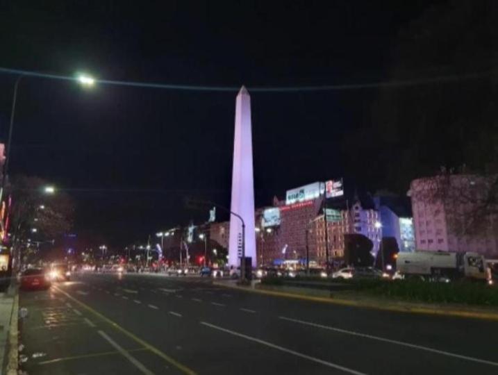 a city street at night with a obelisk at Hostal 2 in Buenos Aires