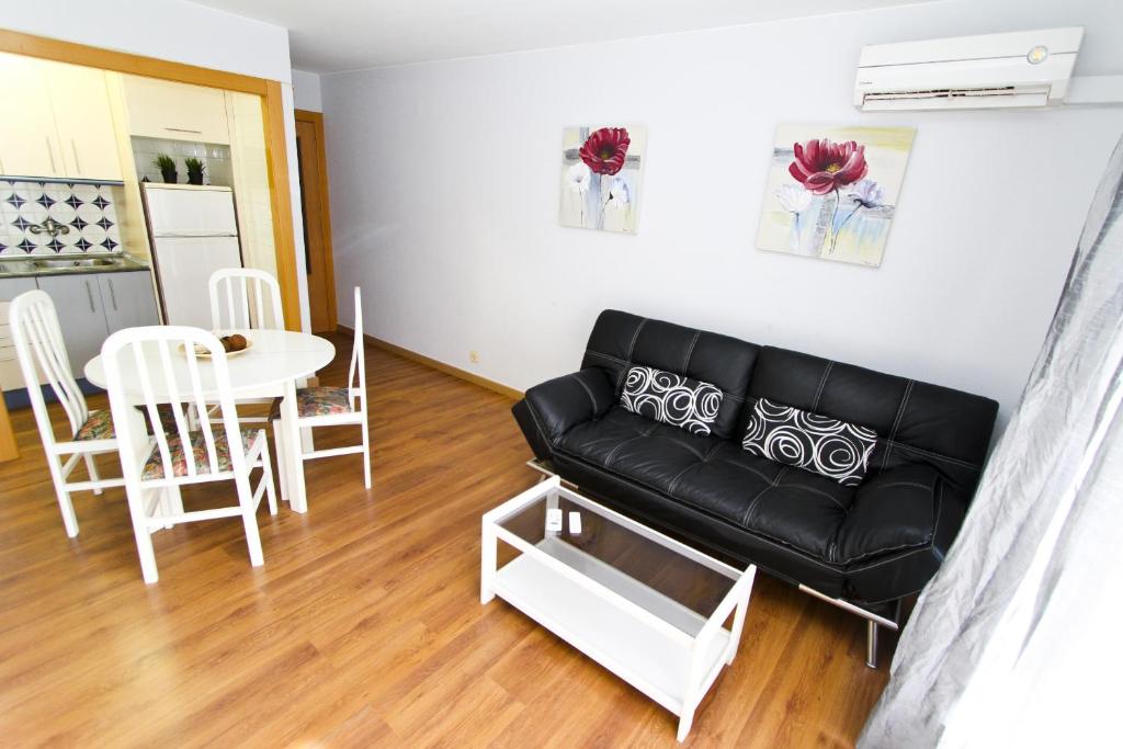 a living room with a black couch and a table at Mexico Planetcostadorada in Vilafortuny