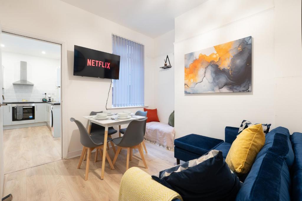 a living room with a blue couch and a table at Spacious 4 bed - 4 en-suites - Parking - Discounts in Doncaster