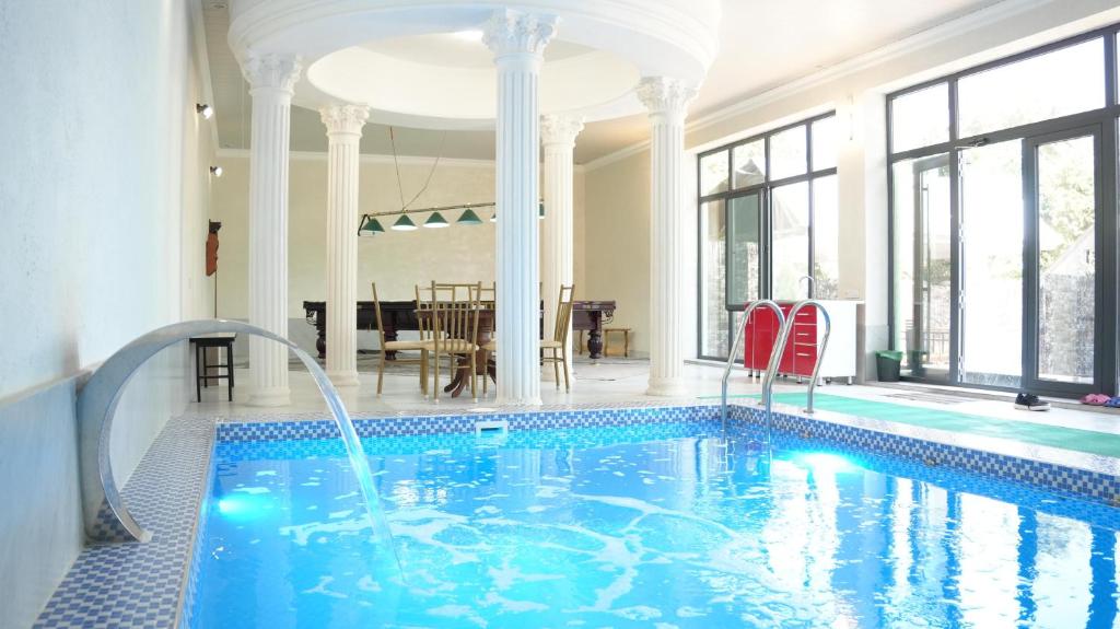 a swimming pool in a house with a large room at Royal Pool Cottage in Shymkent