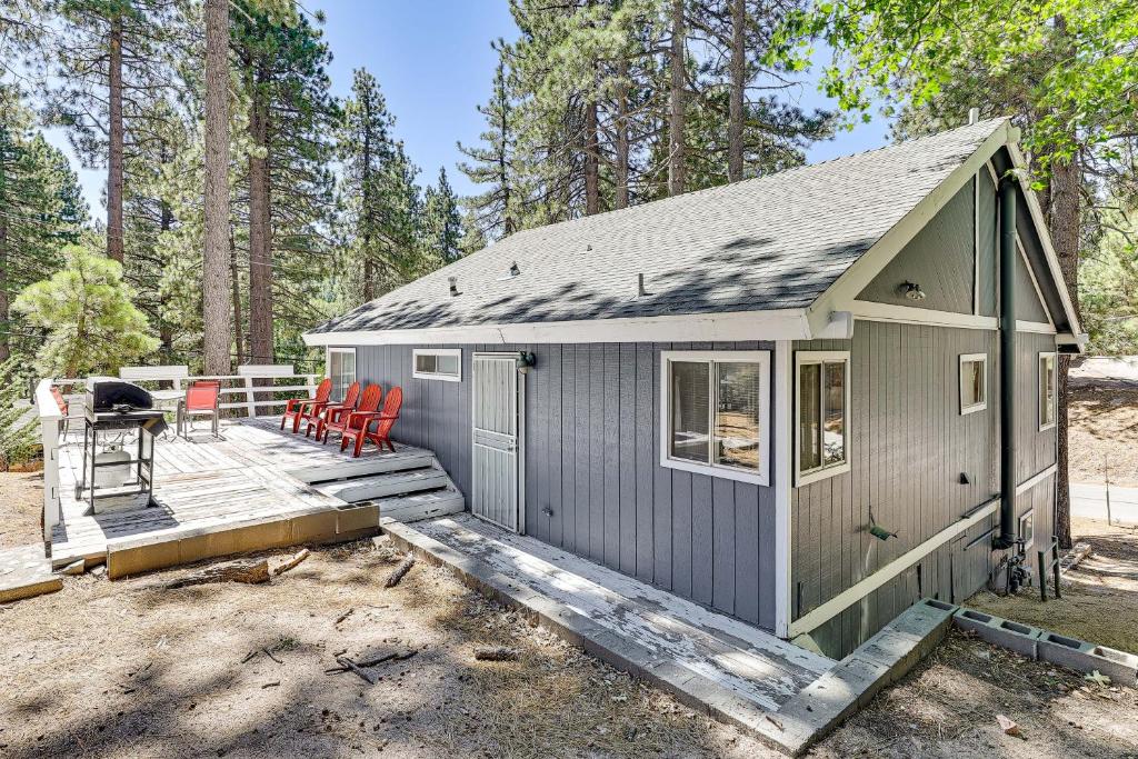 ein winziges Haus mit einer Terrasse im Wald in der Unterkunft Swim, Ski and Explore Cabin in Green Valley Lake! in Green Valley Lake