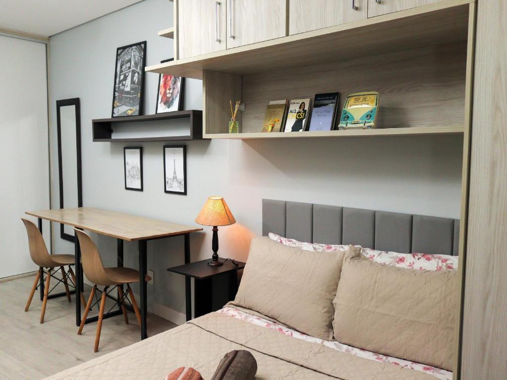 Un dormitorio con una cama, una mesa y un escritorio. en Vanguard Ipiranga, en São Paulo