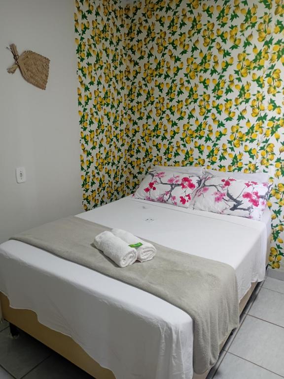a bedroom with a bed with a floral wallpaper at Pousada da Sami in Barra de São Miguel