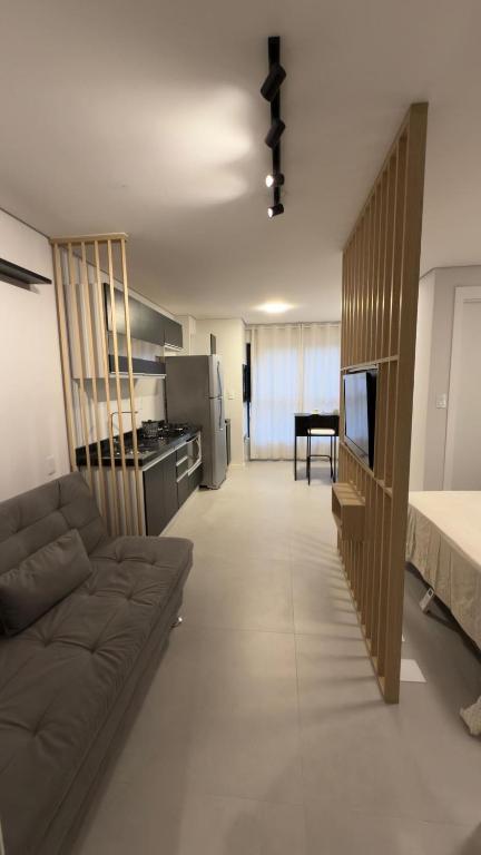 a large living room with a couch and a bed at Loft Moderno no Centro de Blumenau in Blumenau