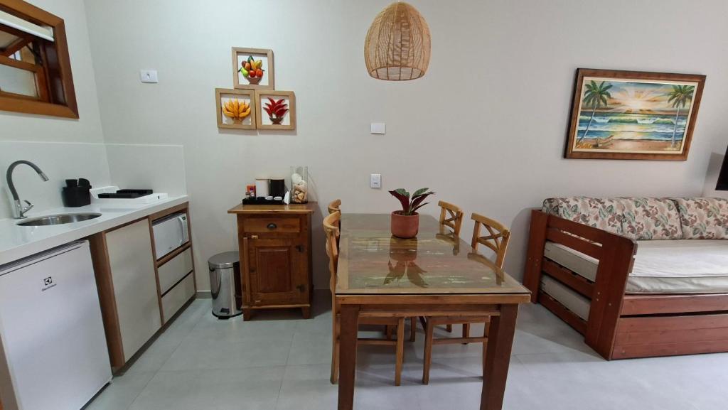 een keuken en woonkamer met een tafel en een bank bij Ilha Flat 4-106 in Ilhabela