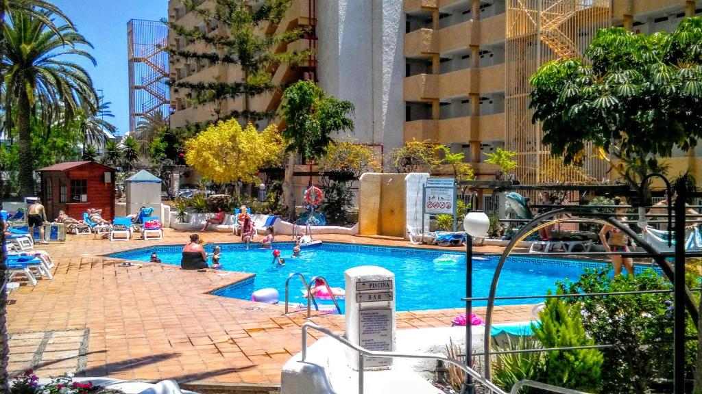 una gran piscina con gente en un edificio en La Rosa De Ponde, en Playa de las Américas