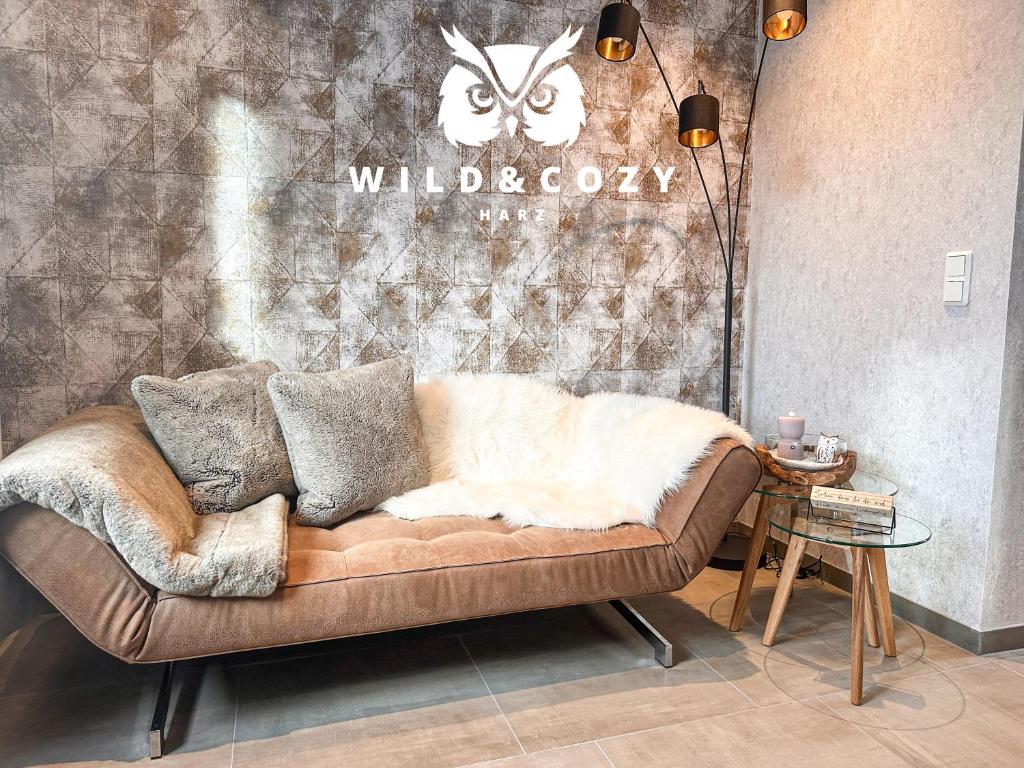 a brown couch with a white blanket on top of it at WILD&COZY Apartment mit moderner Küche & Terrasse in Blankenburg