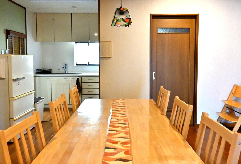 eine Küche mit einem langen Holztisch und Stühlen in der Unterkunft Villa Izumi Eternity and a Day in Izumi