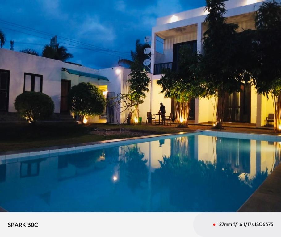 a house with a swimming pool at night at KITHULA Boutique Hotel in Hikkaduwa
