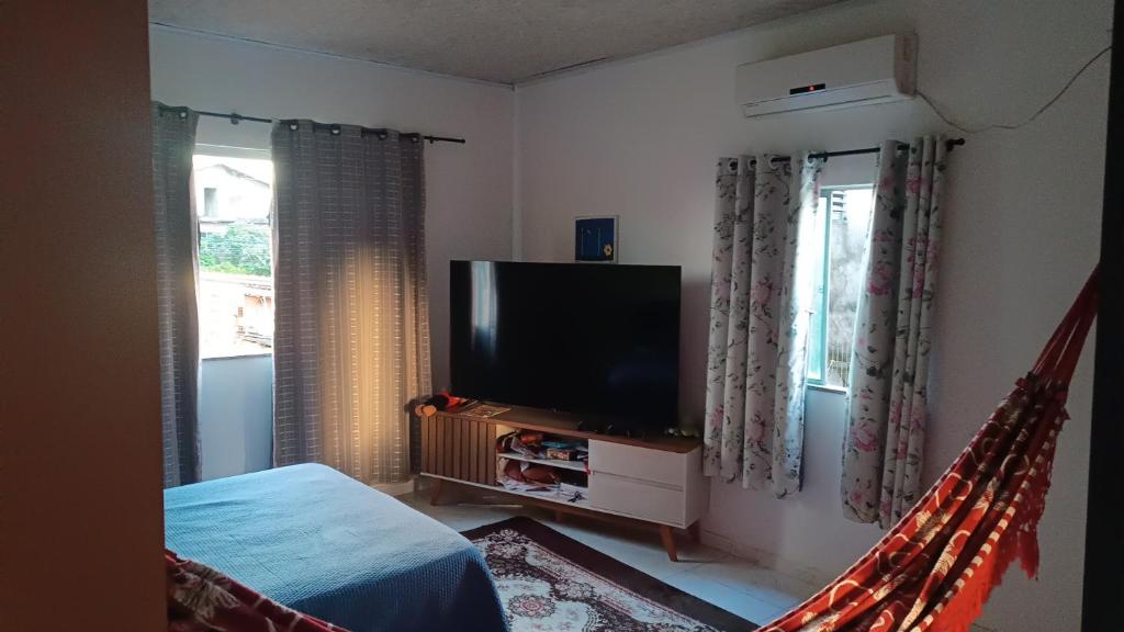 a bedroom with a tv and a bed and a window at Alugo Suítes Confortáveis para COP 30 in Belém