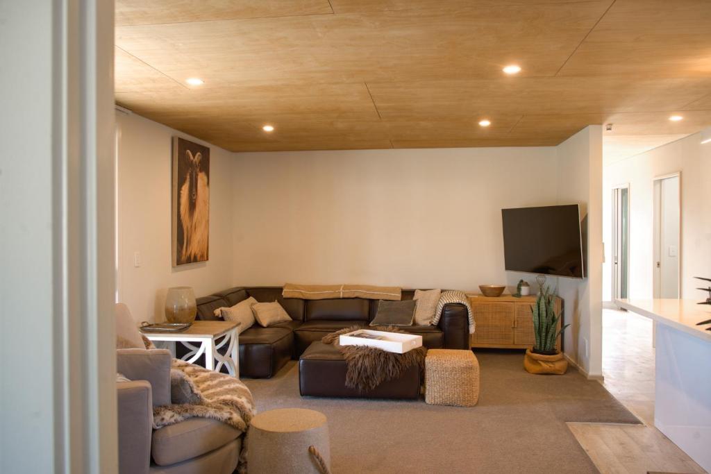 Una sala de estar con un sofá y un televisor de pantalla plana. en No3onfraser, en Twizel