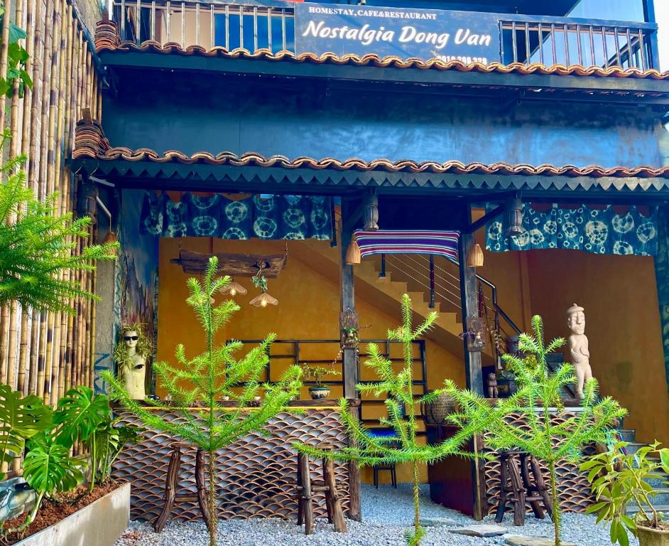 a building with a table and chairs in front of it at Nostalgia DongVan Homestay Ha Giang in Dồng Văn