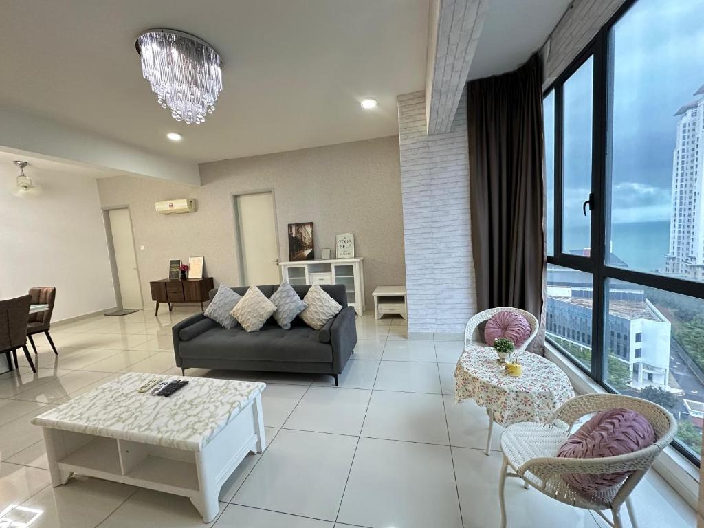 un soggiorno con un divano e un tavolo di Deluxe Seaview Suite Tripe Bed with bath tub 13A a Tanjong Tokong