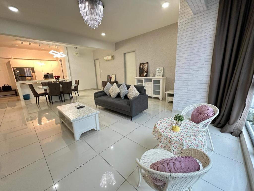 a living room with a couch and a table and chairs at Deluxe Seaview Suite Tripe Bed with bath tub 13A in Tanjong Tokong