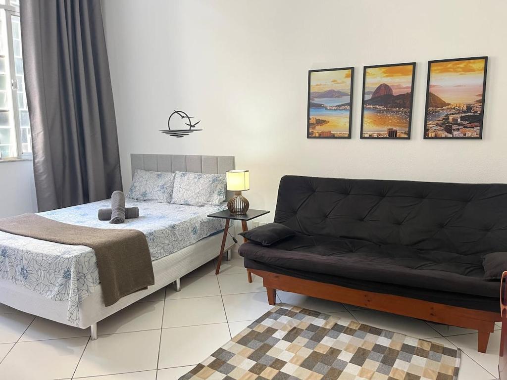 a bedroom with a bed and a couch at Stúdio no Centro- Lapa, Consulado, Praia e Metrô! 1101 in Rio de Janeiro