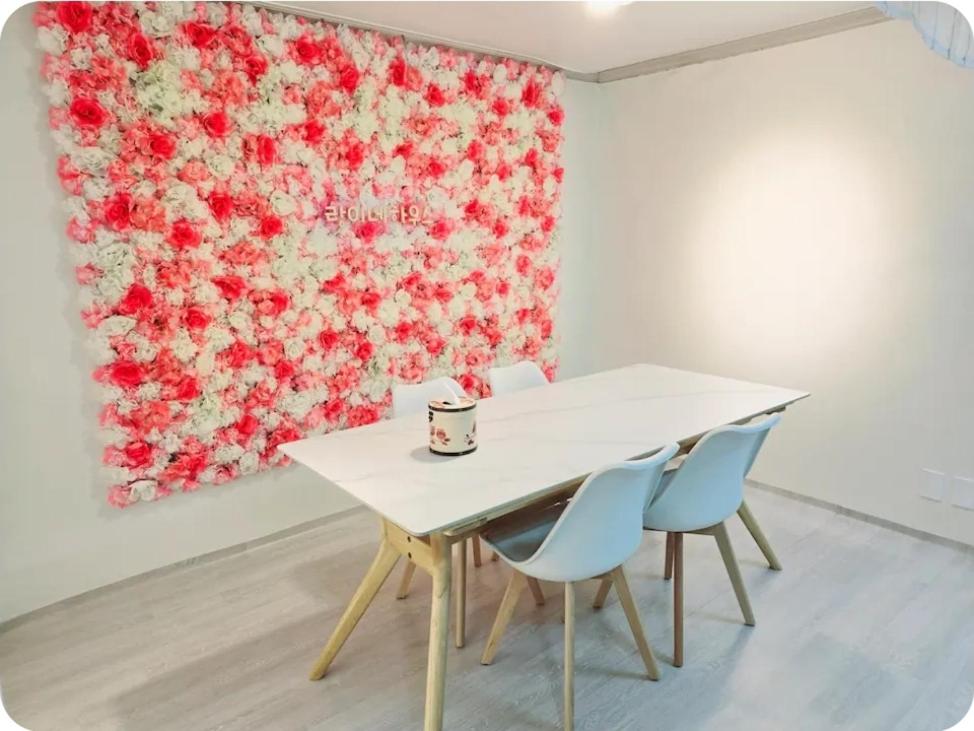 una mesa y sillas en una habitación con una pintura en Rang House, en Puwŏl-li
