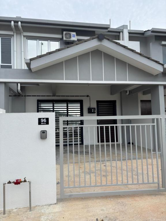 Rizku Homestay Port Dickson 4 Bedroom 4 Bathroom في باسير بانجانغ: منزل أمامه بوابة