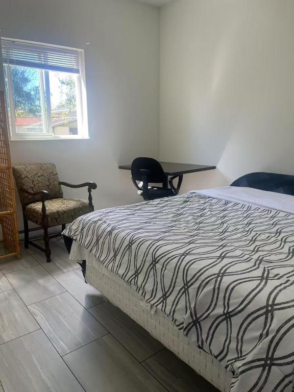 Un dormitorio con una cama, una silla y una mesa. en three bedroom two near uvic 1, en Oak Bay