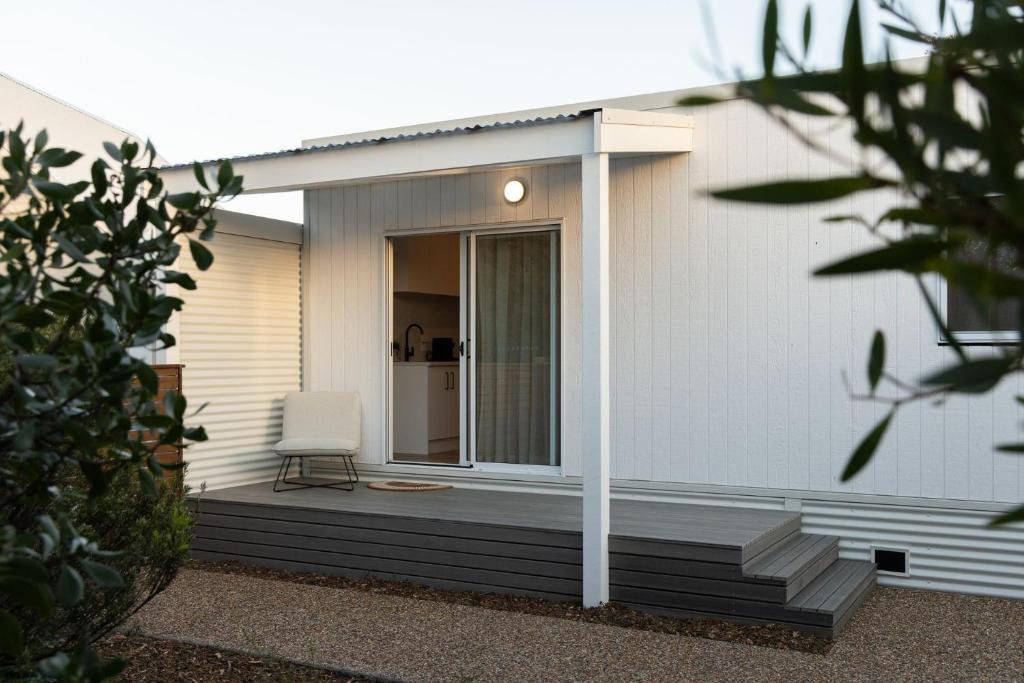 a house with a deck with a chair on it at Island Beach Retreat in Surf Beach