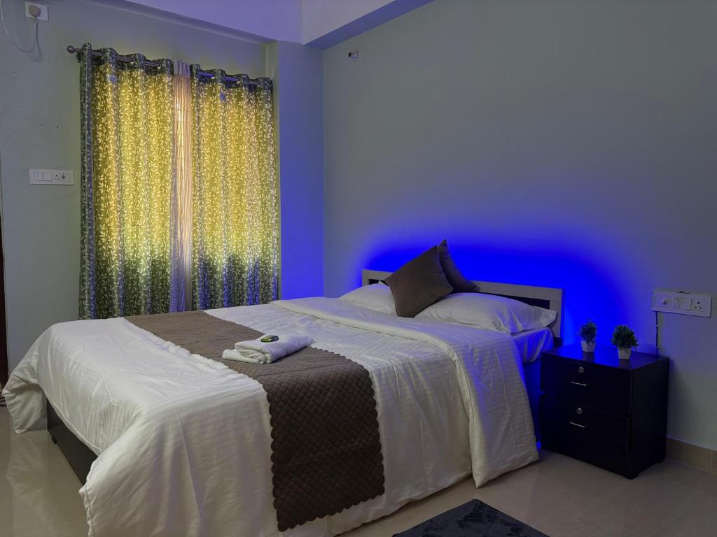 a bedroom with a large bed with a blue light at DXK Villa Homestay in Guwahati