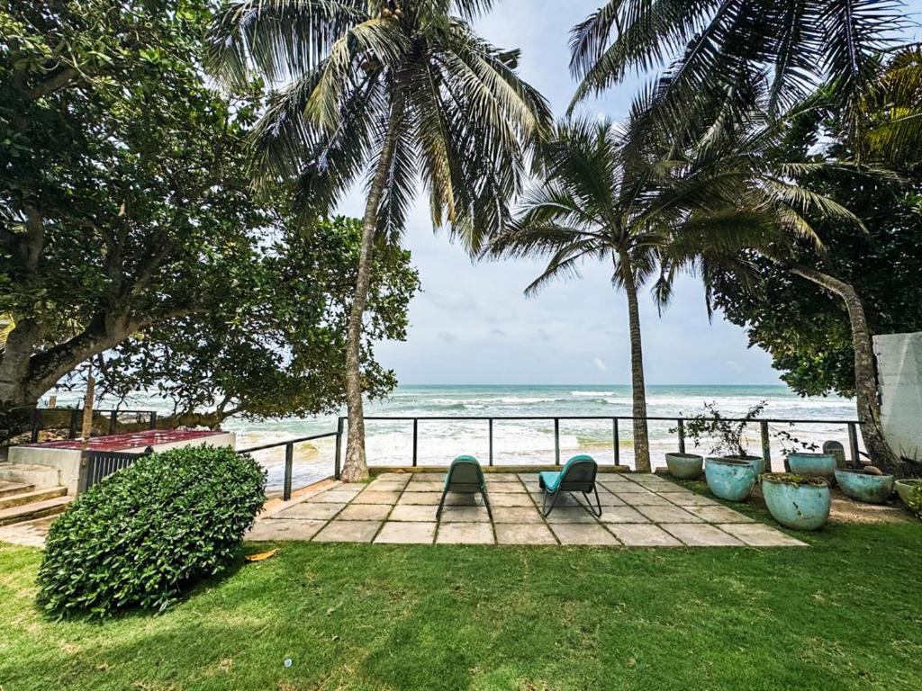 a patio with a view of the beach at Marleys Beach House in Talpe