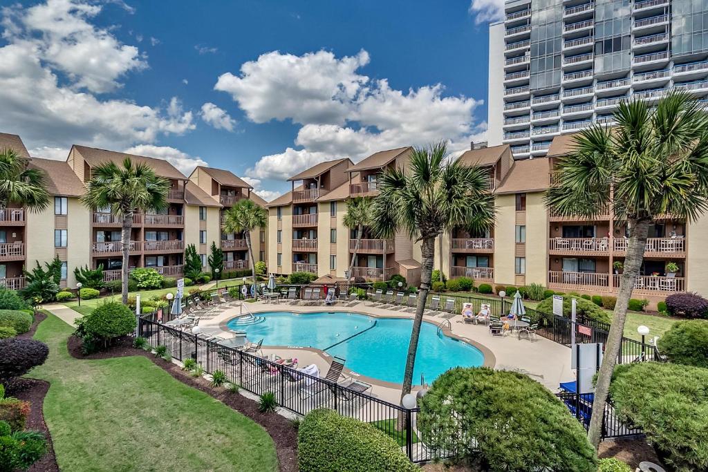 an apartment complex with a swimming pool and palm trees at Anchorage II B04 in Myrtle Beach