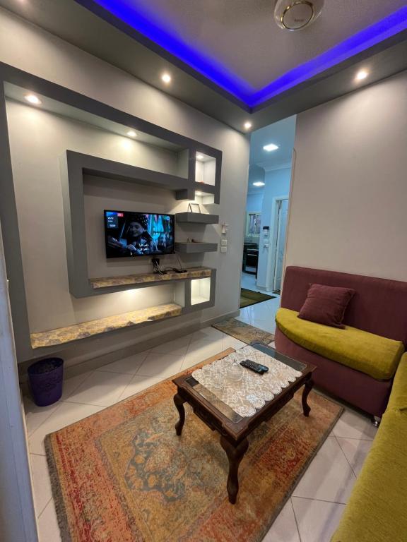 a living room with a tv and a couch and a table at Roma Apartment LXR in Luxor