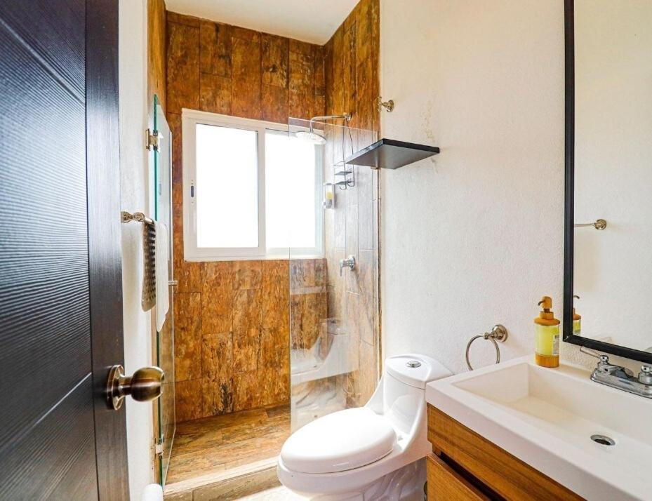 a bathroom with a toilet and a sink and a shower at Private house with two pools for up to 25 people in Atlacholoaya