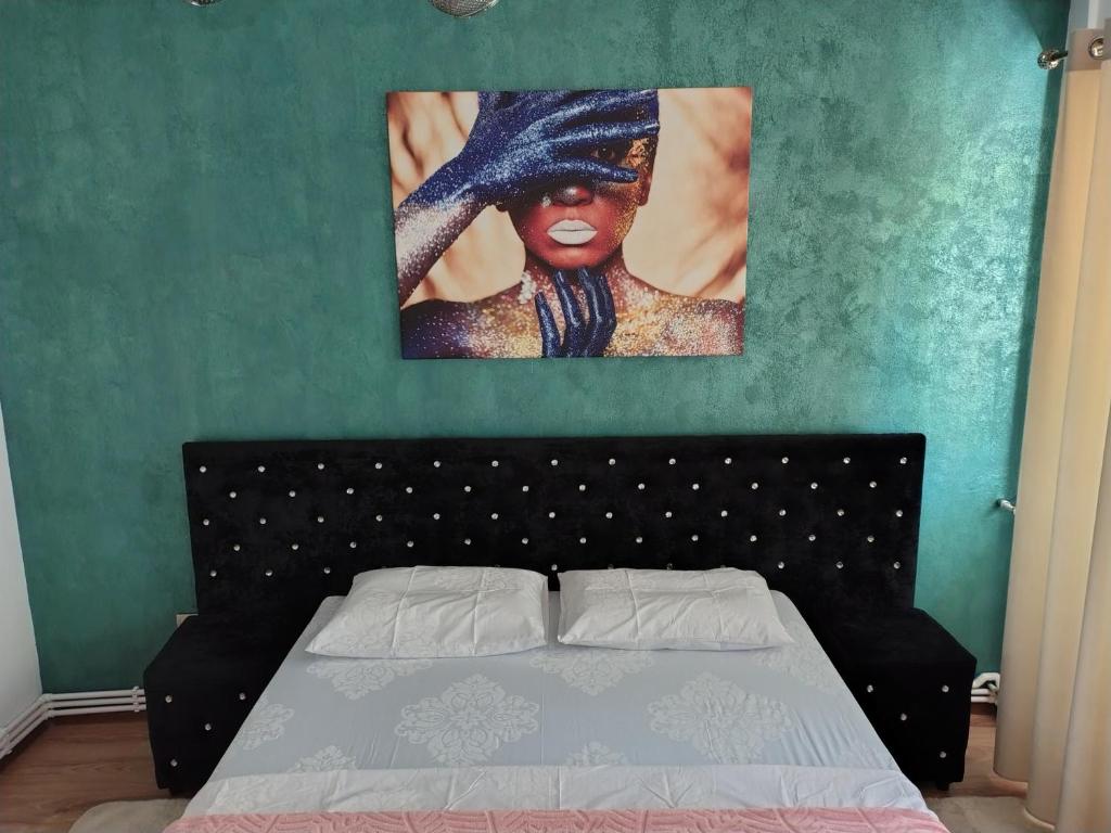 a bedroom with a bed and a painting on the wall at Apartament Justin in Galaţi